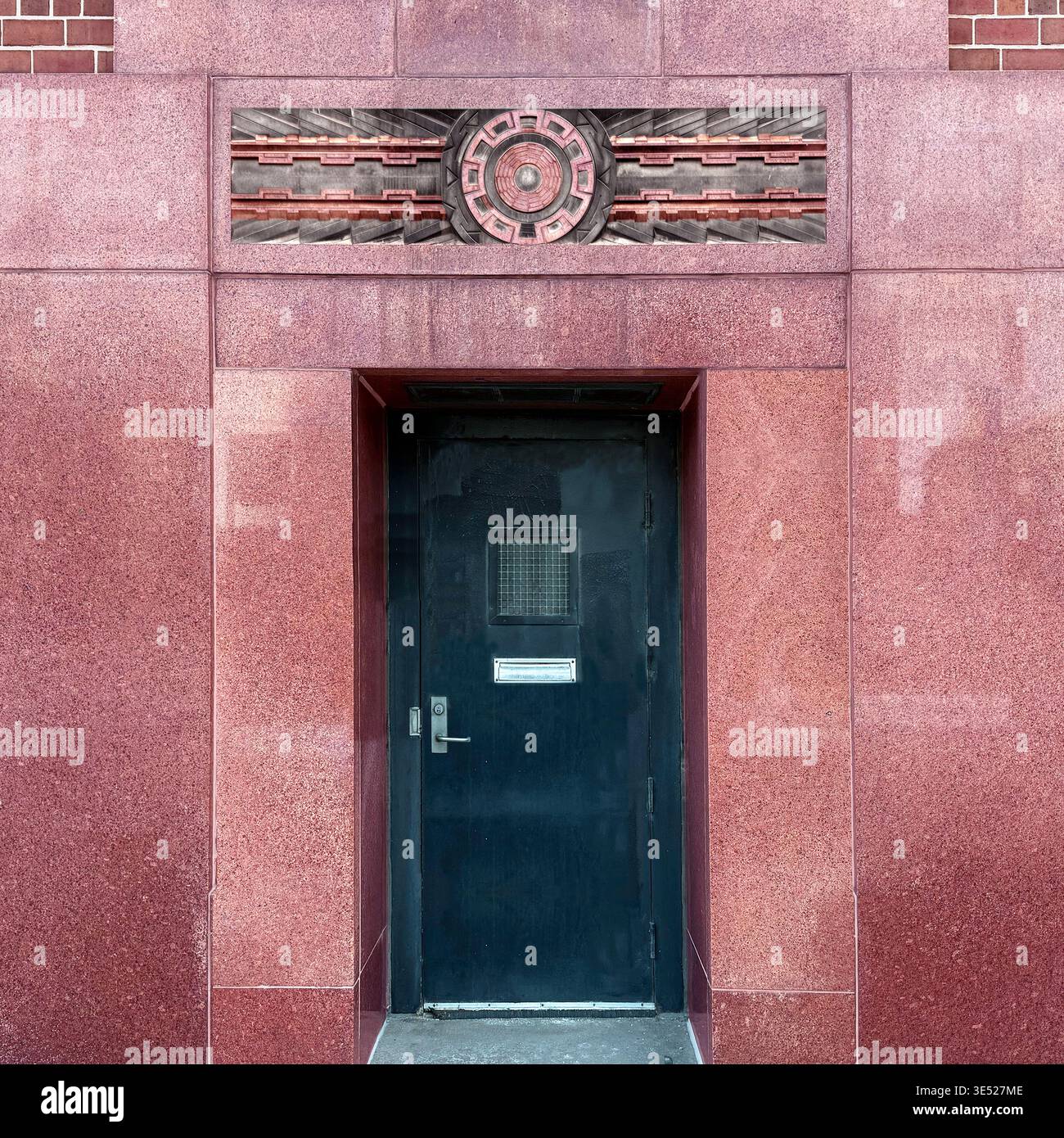 Art Deco doorway with geometric bas-relief in red stone, Chicago. - Smartphone Captured Stock Image