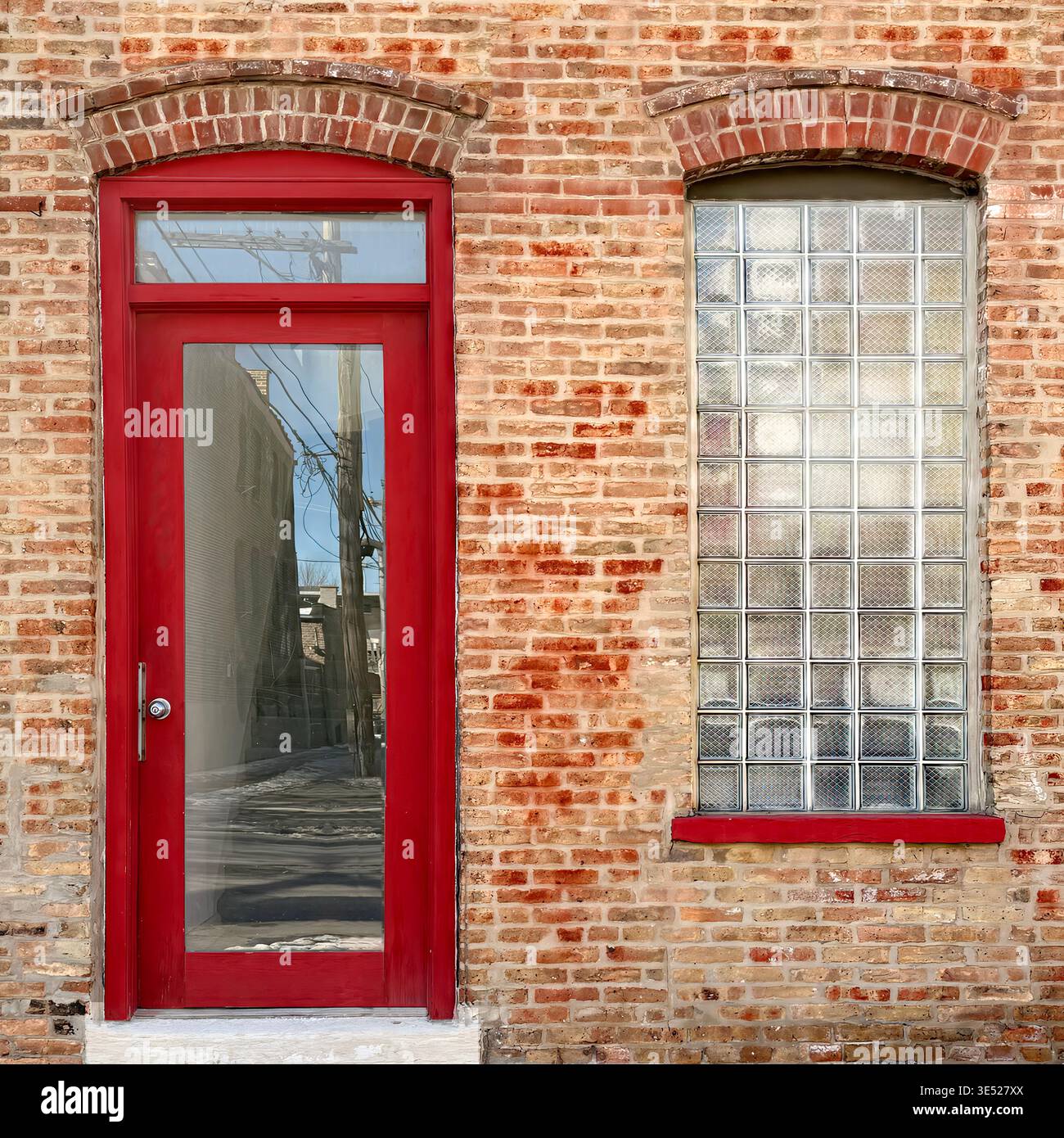 Red door and glass block window set in a brick facade, Chicago. - Smartphone Captured Stock Image