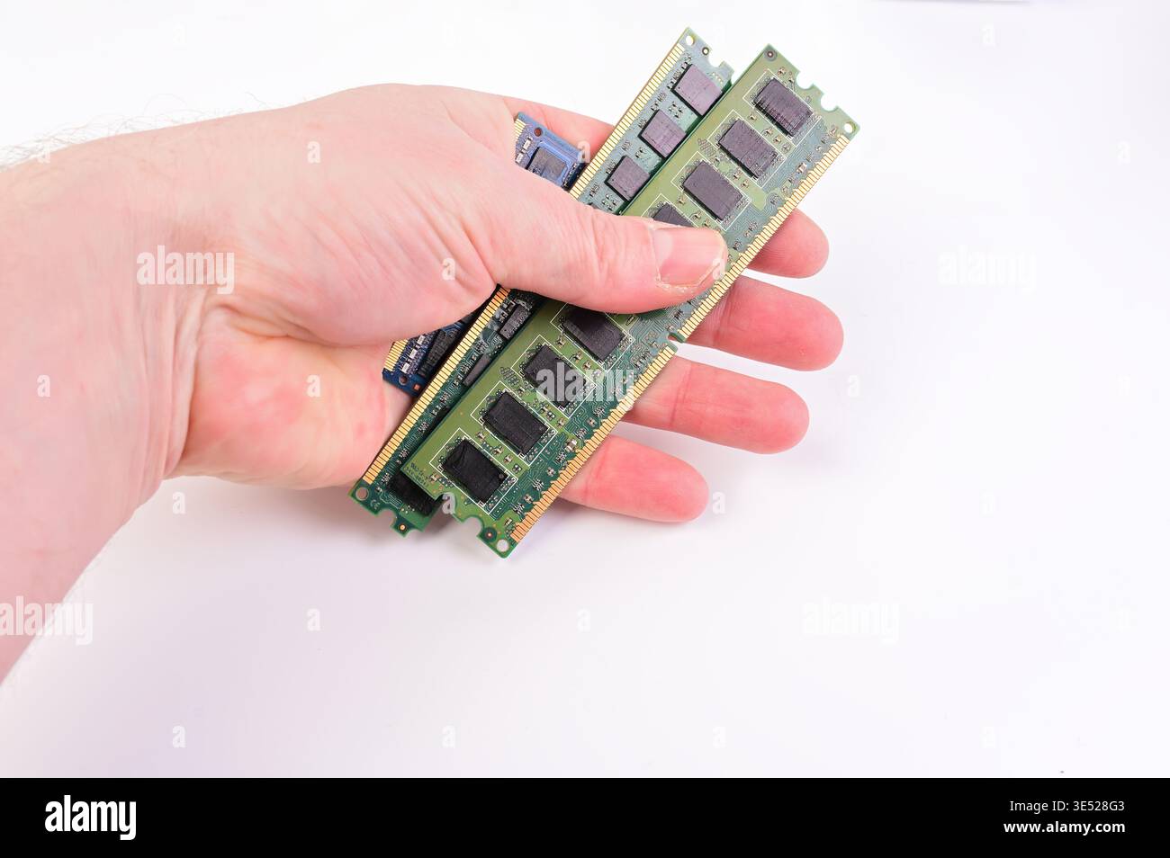 Hand holding multiple computer RAM modules on a white background Stock Photo