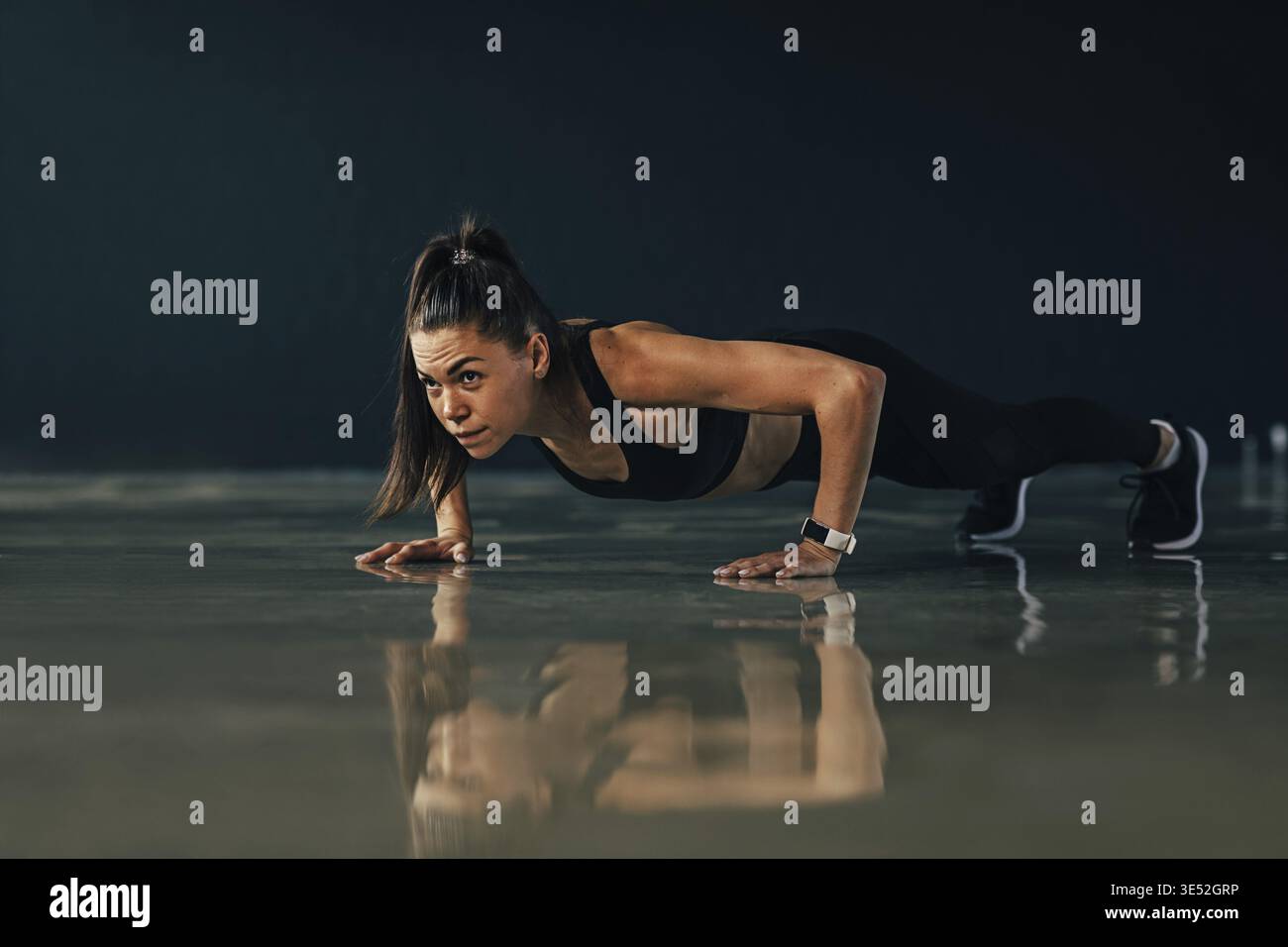 Strong woman doing push ups exercises indoors Stock Photo