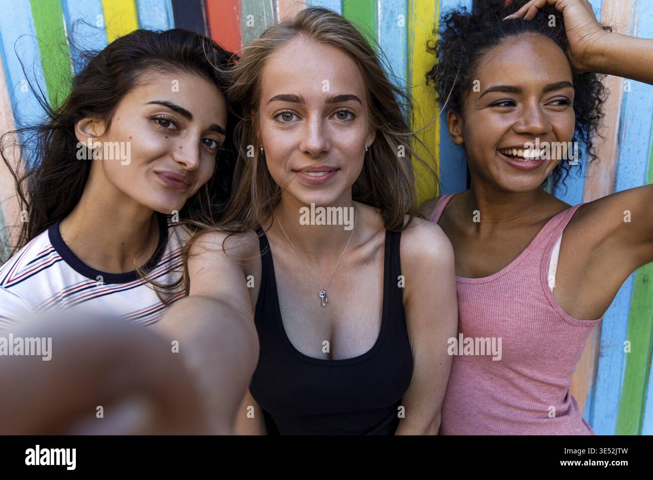 Group of young friends posing while taking selfie. Three smiling women having fun Stock Photo