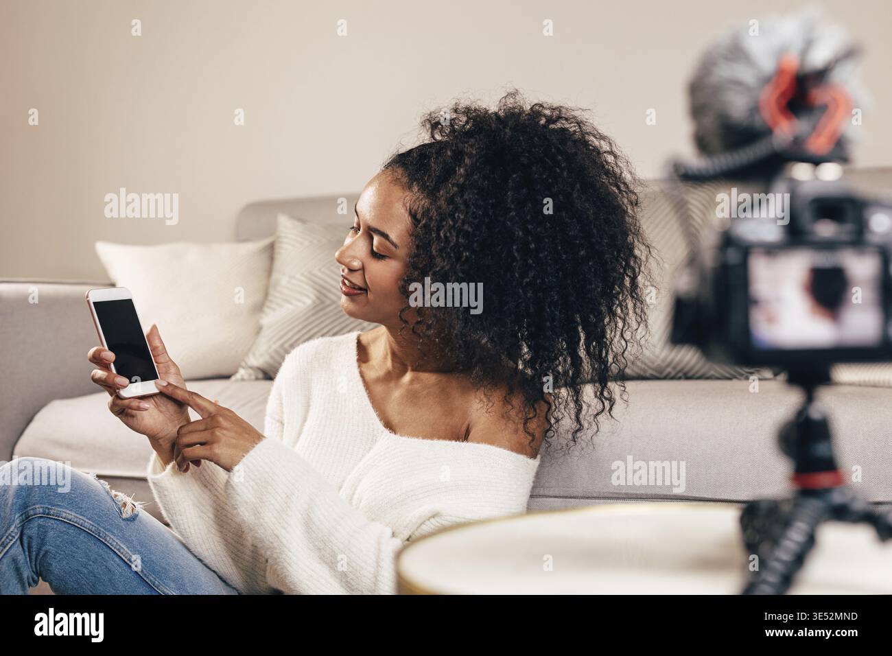 Female vlogger using smartphone while recording a video Stock Photo