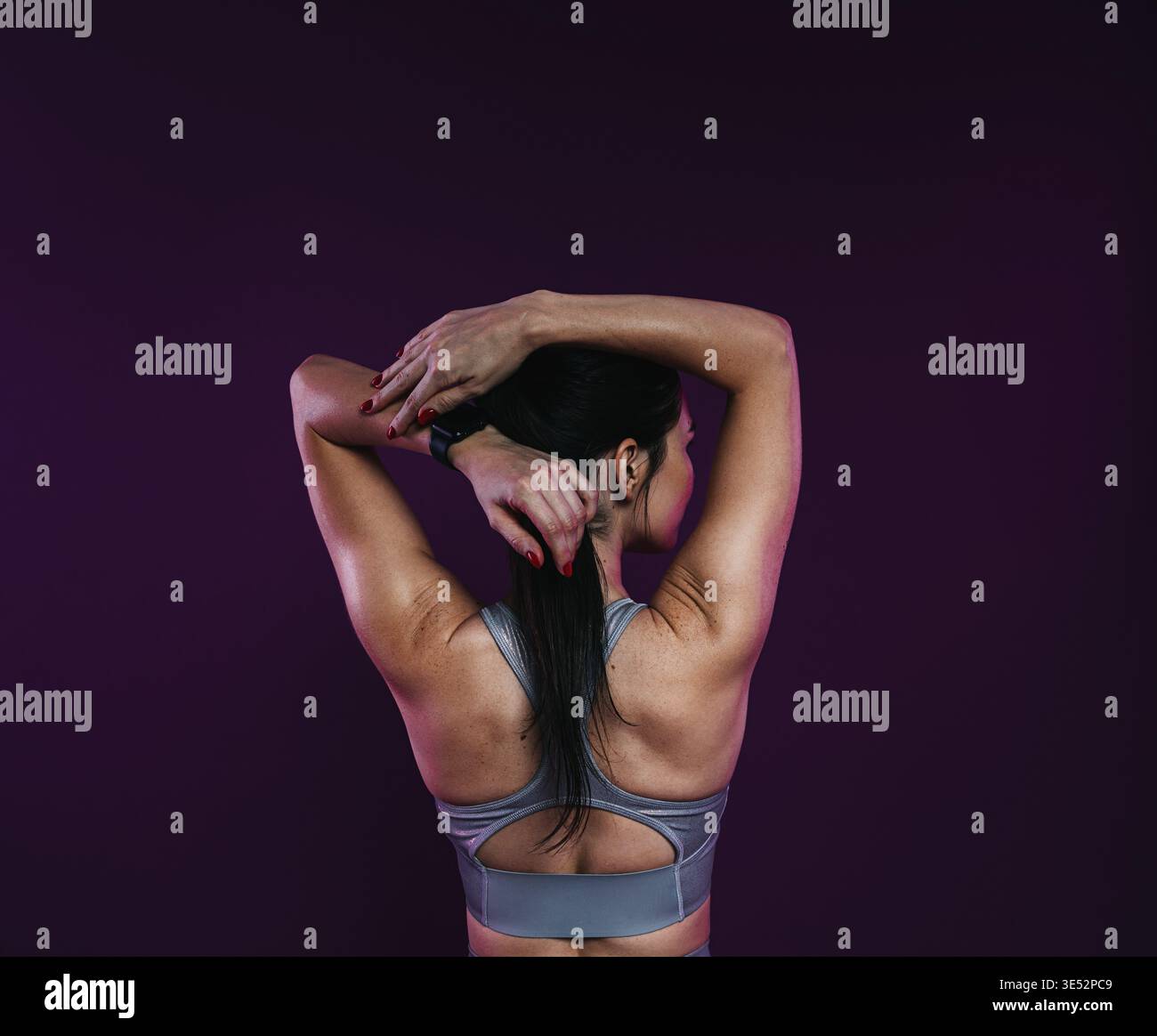 Back view of a young athlete stretching her arms before workout Stock Photo