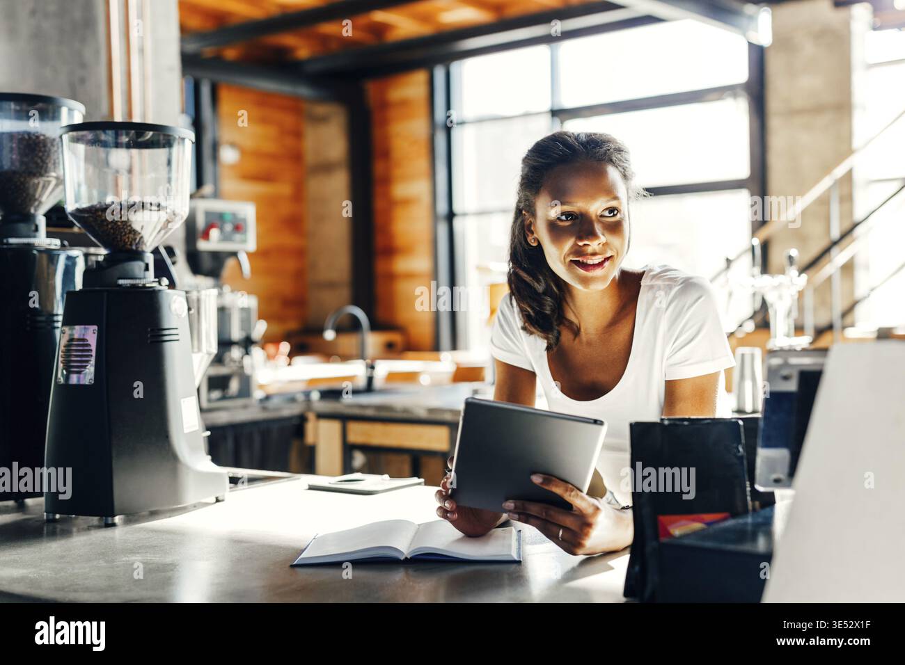 Cafe owner using digital tablet at counter Stock Photo