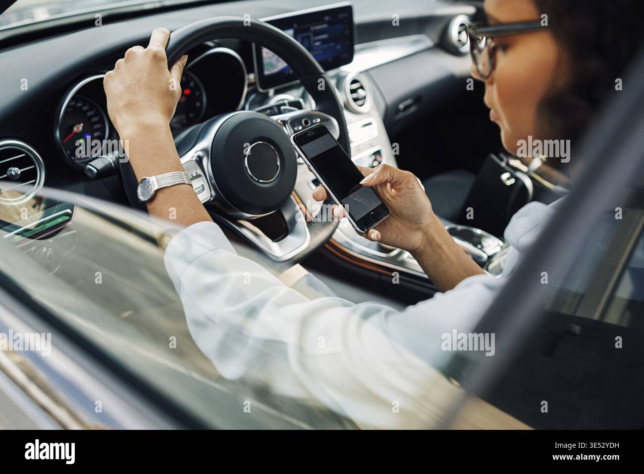 Unrecognizable woman using smartphone while sitting in car Stock Photo