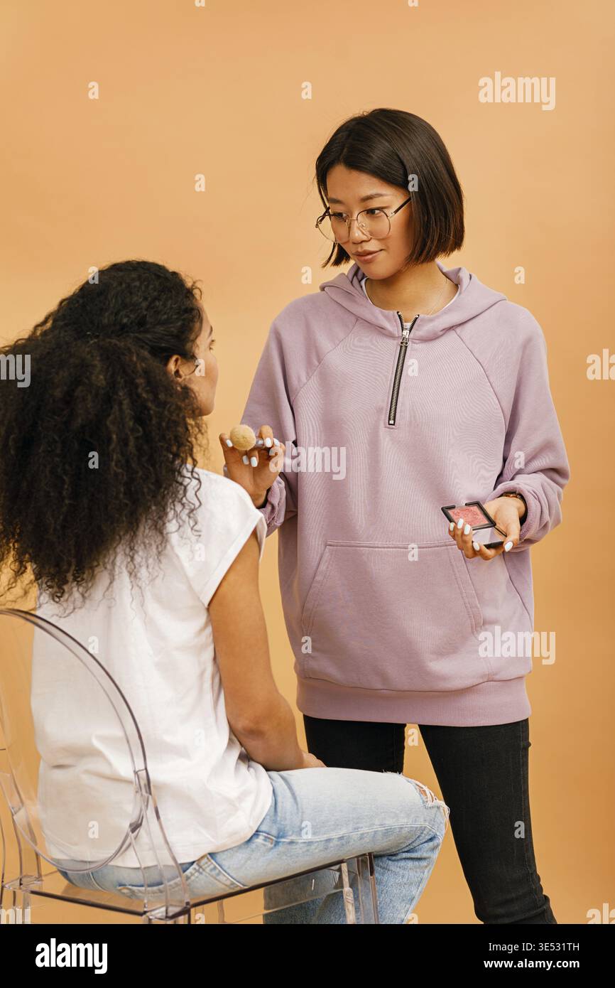 Young make up artist working with model in studio Stock Photo
