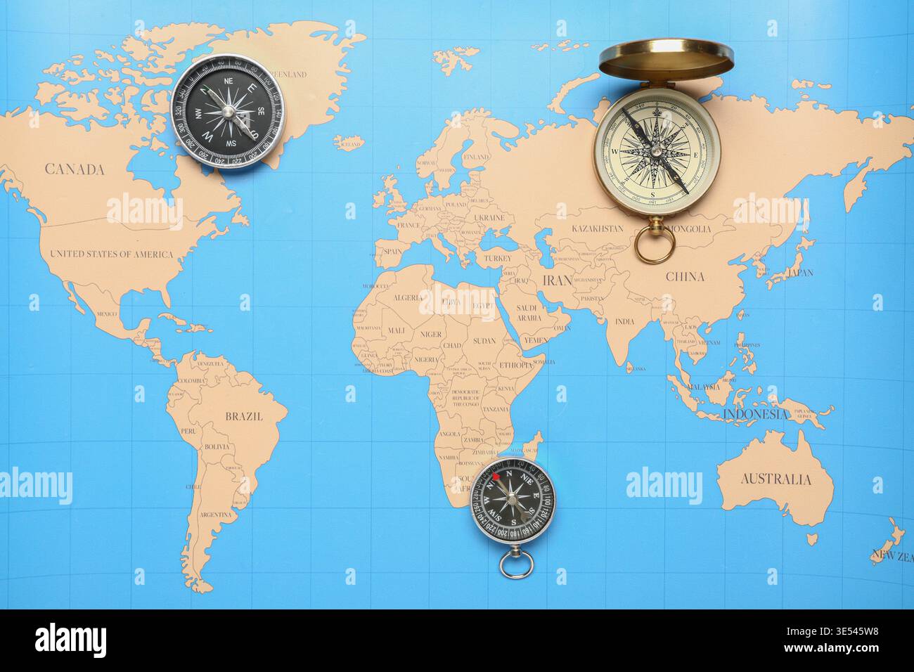 Different modern compasses on world map as background Stock Photo