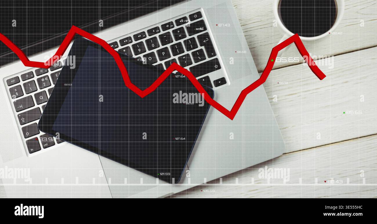 Displaying silver laptop with black tablet diagonally on white desk, coffee cup, red trend overlay Stock Photo