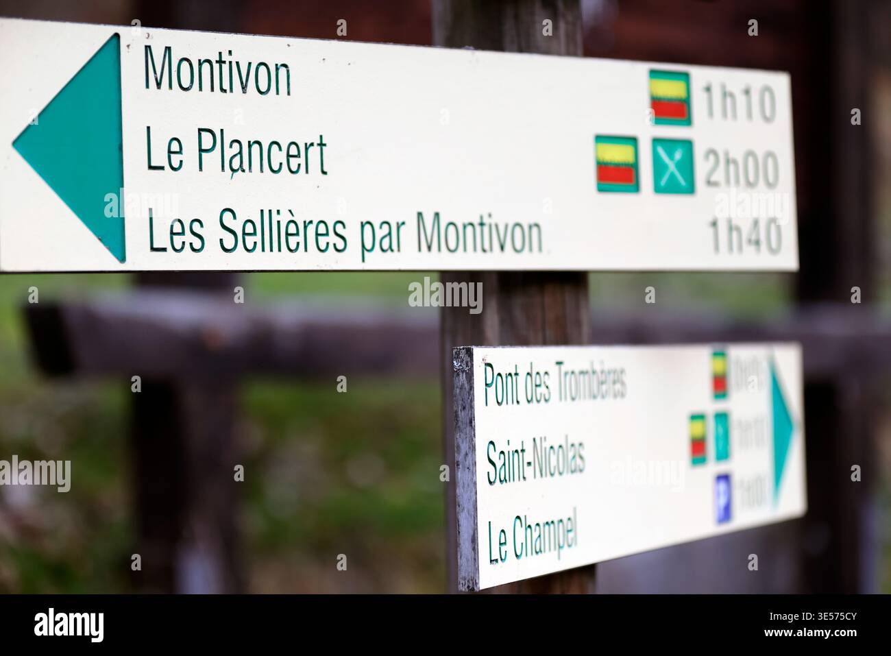 Color-coded mountain trail signs show estimated walking times to several alpine destinations in the area.  Saint Gervais.  France. Stock Photo