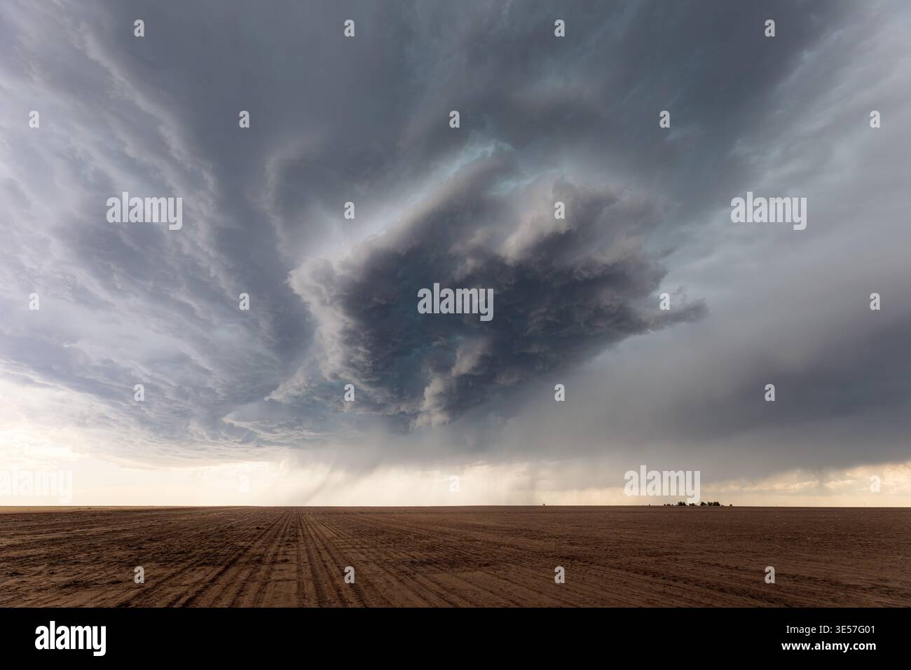 Dark storm clouds from a supercell over a field Stock Photo
