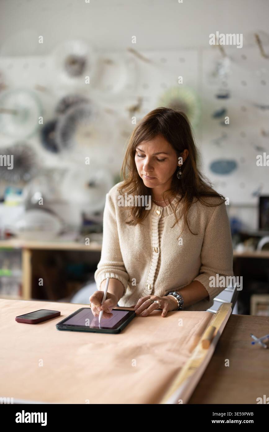Craftswoman working in creative studio, using application on digital tablet Stock Photo