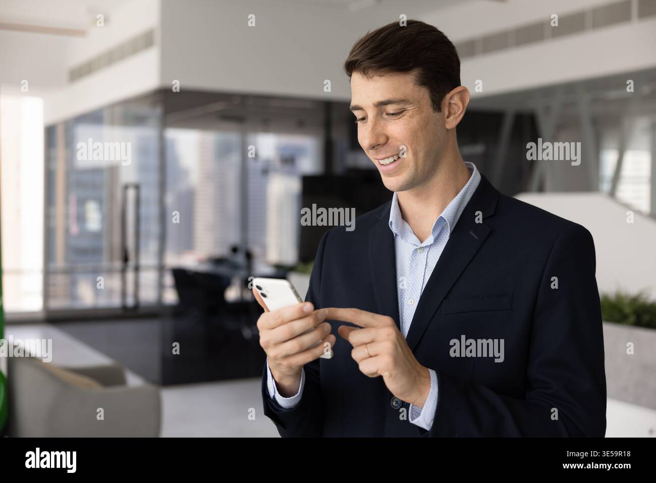 Young businessman using smart phone at workplace Stock Photo