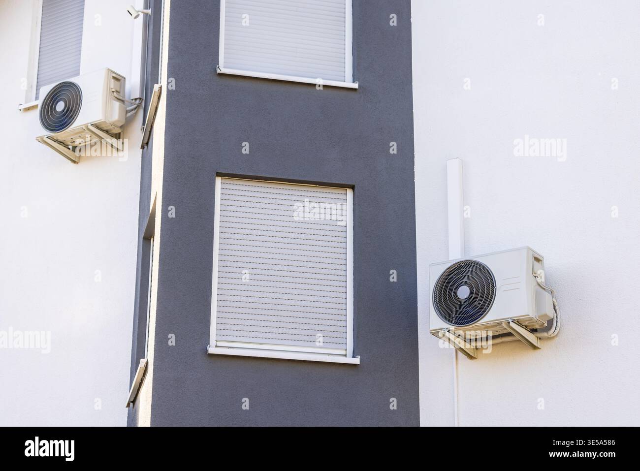 Outdoor unit of a split air conditioning system mounted on a white ...