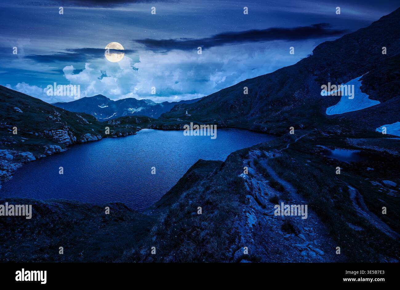 gorgeous summer night over capra lake. full moon over breathtaking view of transylvaia alps in romania. composite background image for mysterious natu Stock Photo