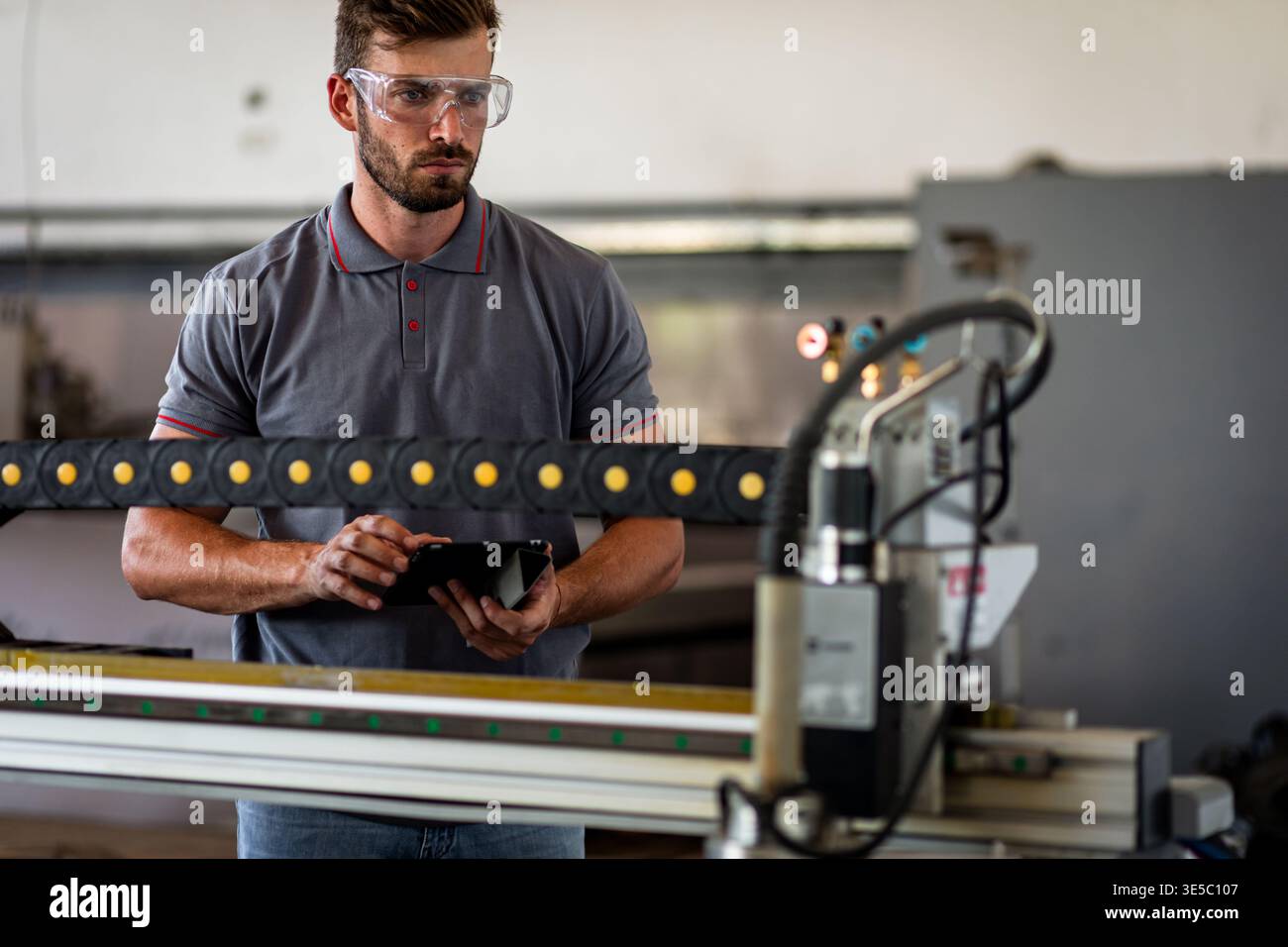 Male engineer setup plasma cutter for work in metalwork workshop. Stock Photo