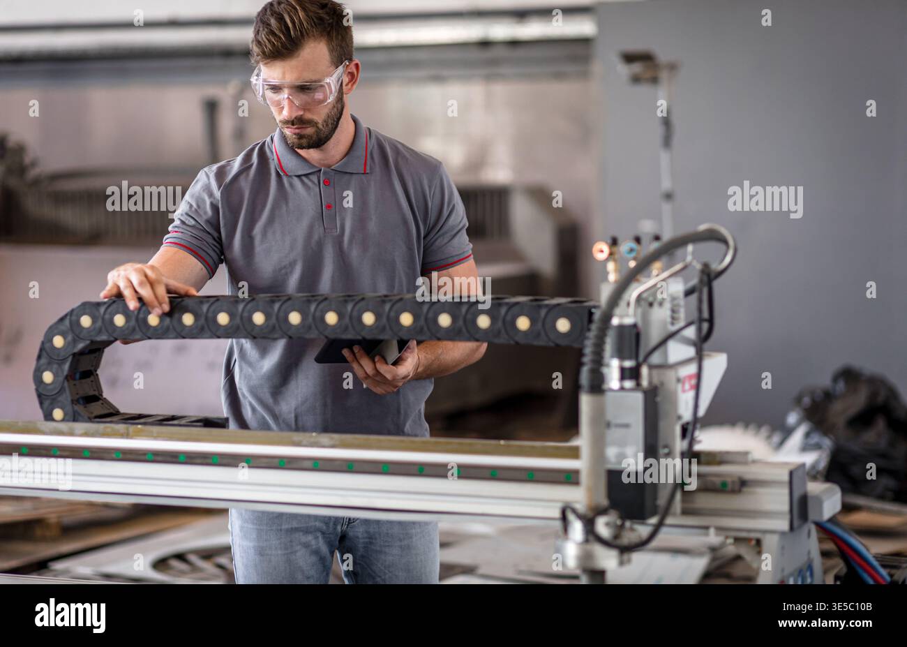 Male engineer setup plasma cutter for work in metalwork workshop. Stock Photo