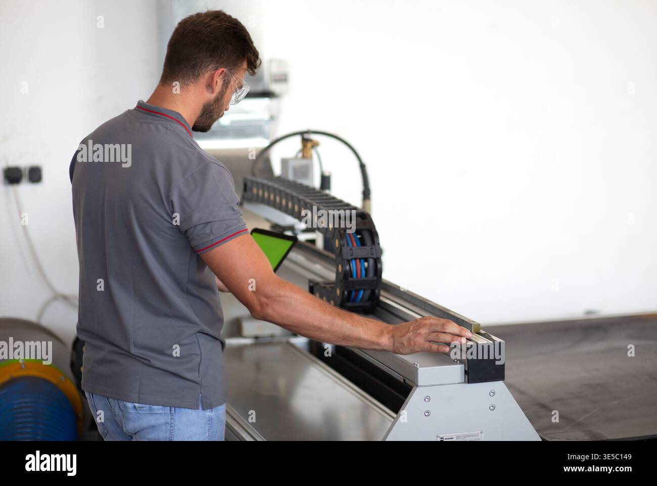 Male engineer setup plasma cutter for work in metalwork workshop. Stock Photo