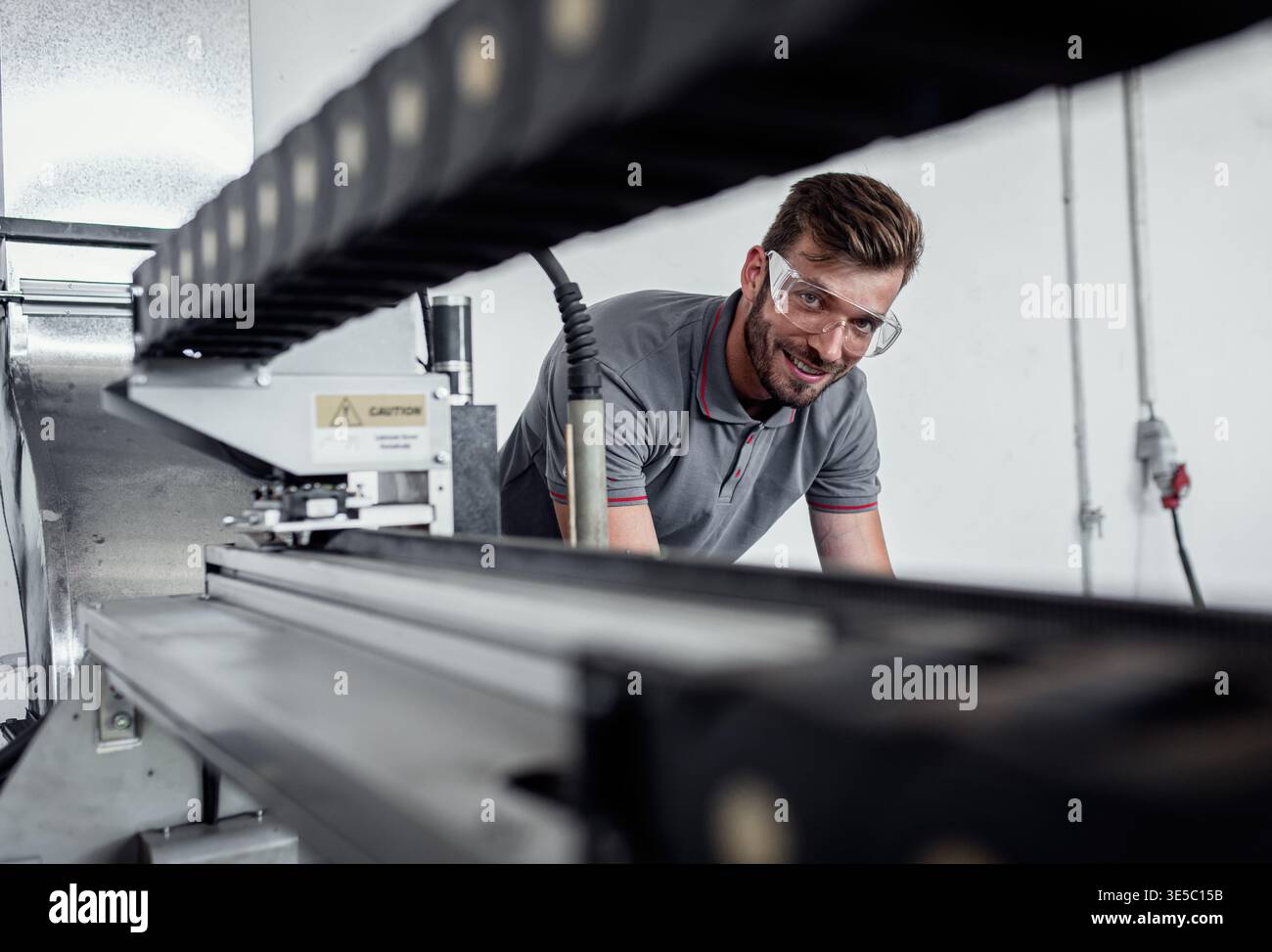 Male engineer setup plasma cutter for work in metalwork workshop. Stock Photo