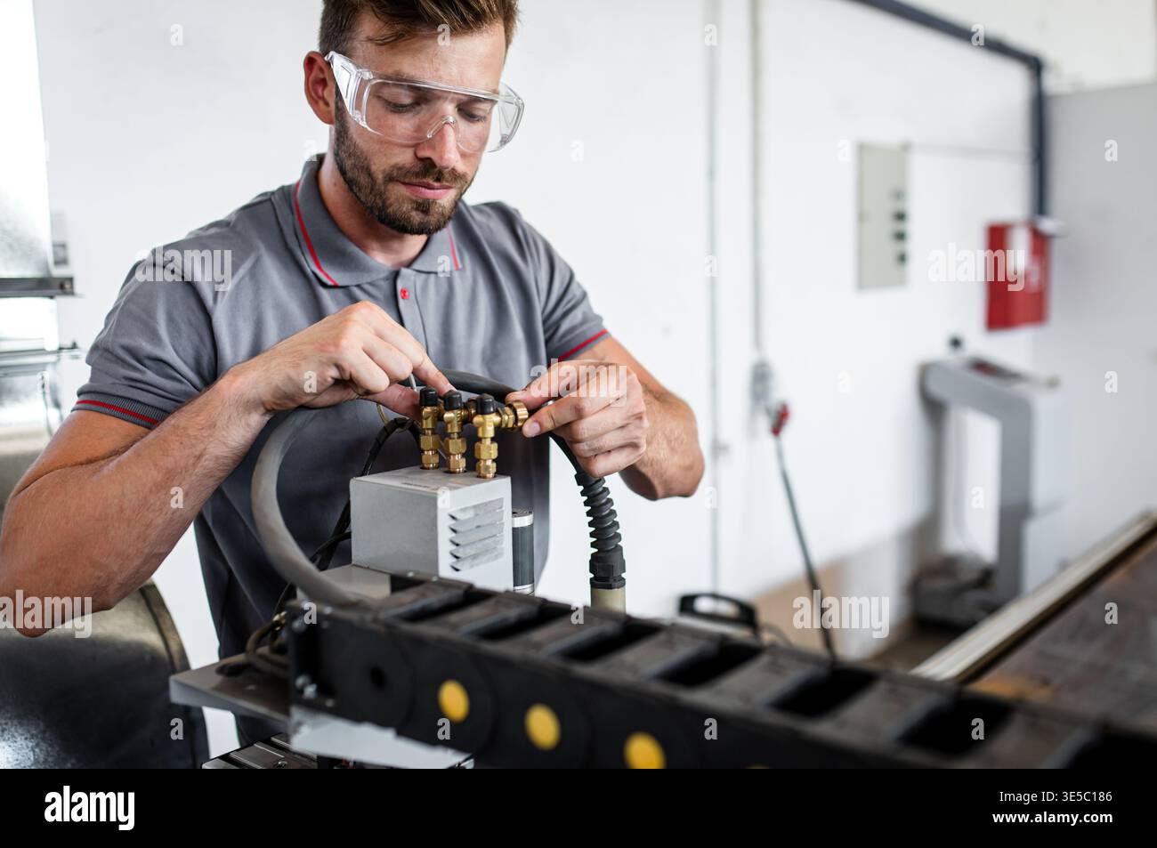 Male engineer setup plasma cutter for work in metalwork workshop. Stock Photo
