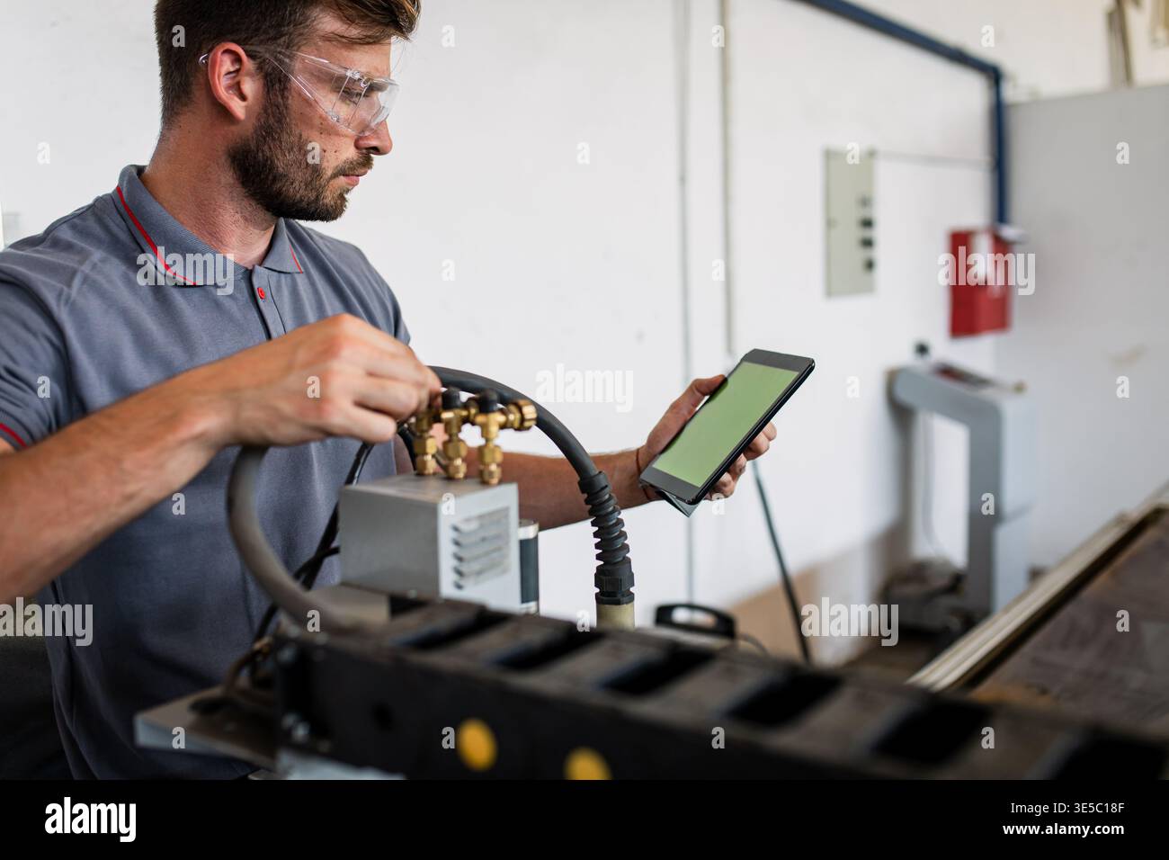 Male engineer setup plasma cutter for work in metalwork workshop. Stock Photo