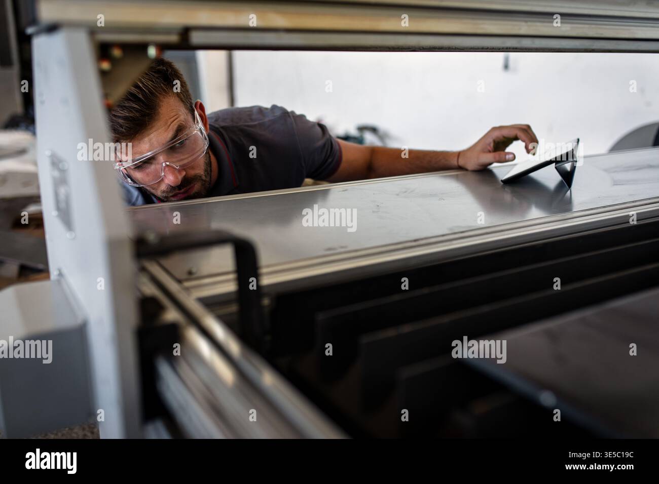 Male engineer setup plasma cutter for work in metalwork workshop. Stock Photo