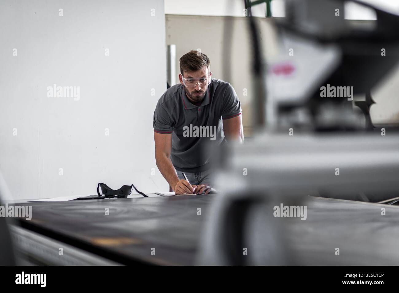 Male engineer setup plasma cutter for work in metalwork workshop. Stock Photo
