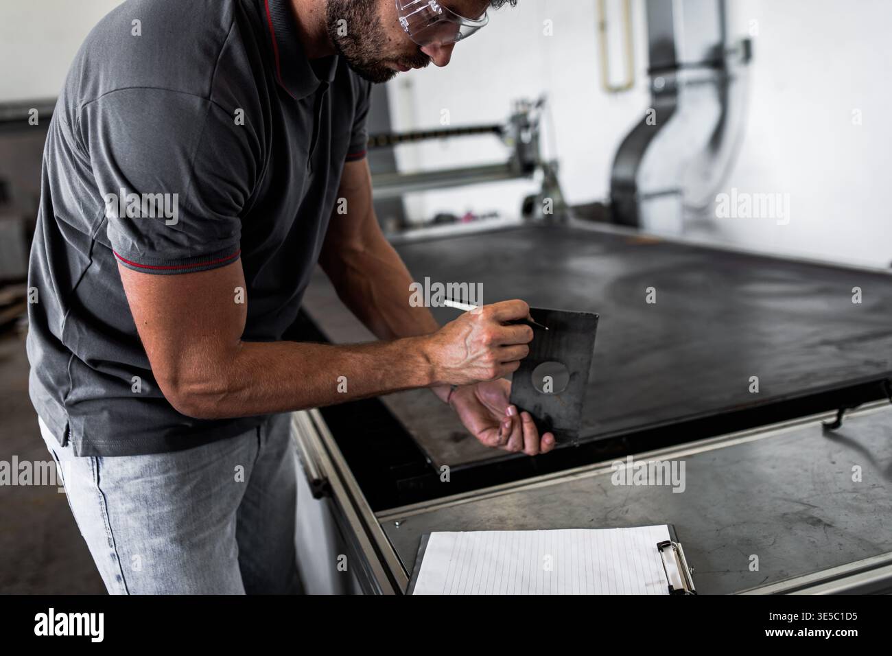 Male engineer setup plasma cutter for work in metalwork workshop. Stock Photo