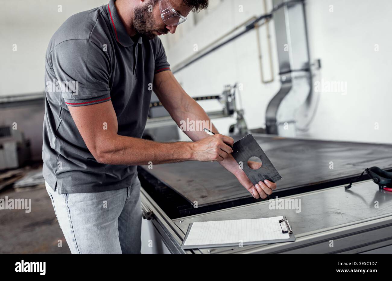 Male engineer setup plasma cutter for work in metalwork workshop. Stock Photo