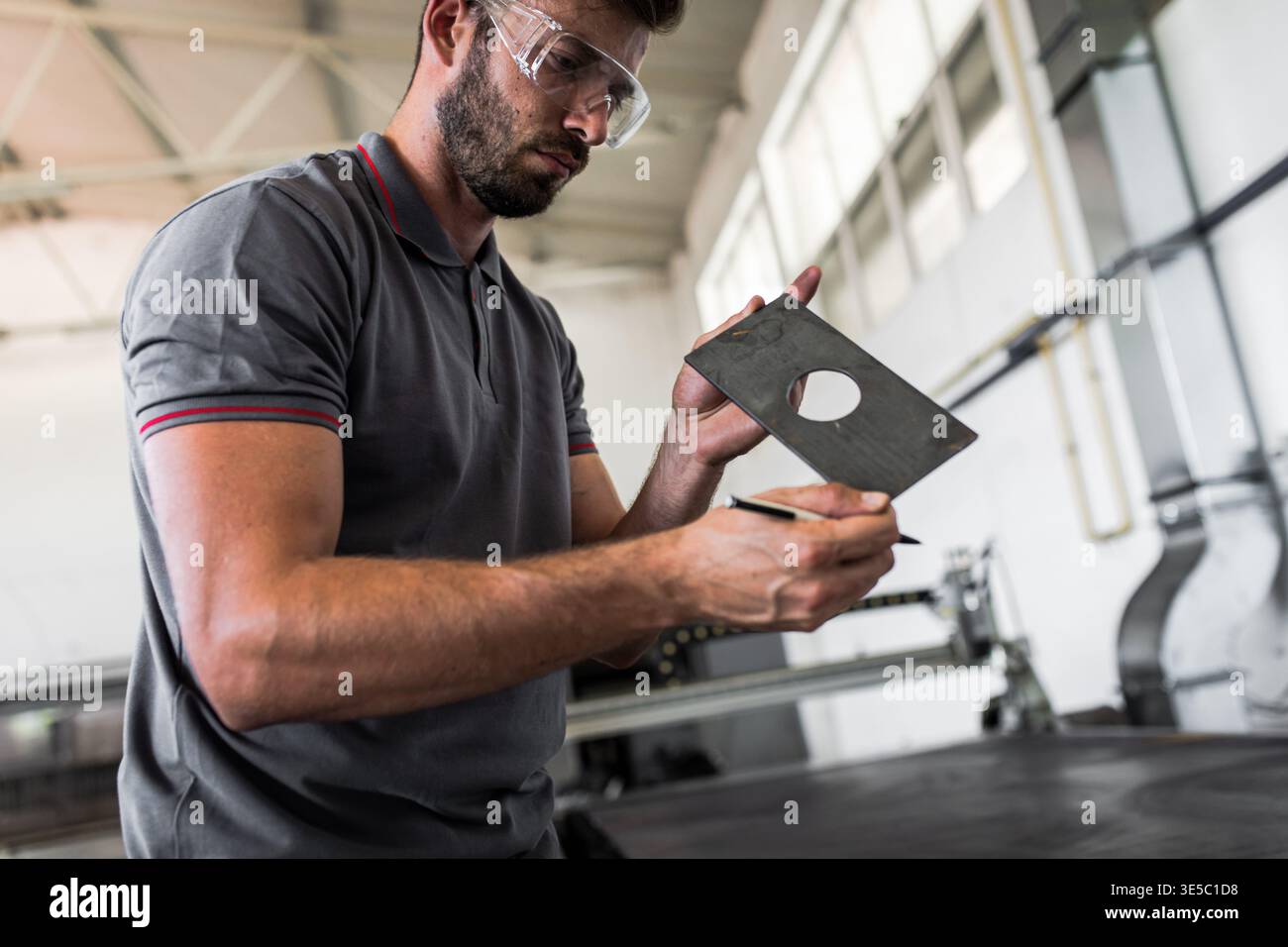 Male engineer setup plasma cutter for work in metalwork workshop. Stock Photo