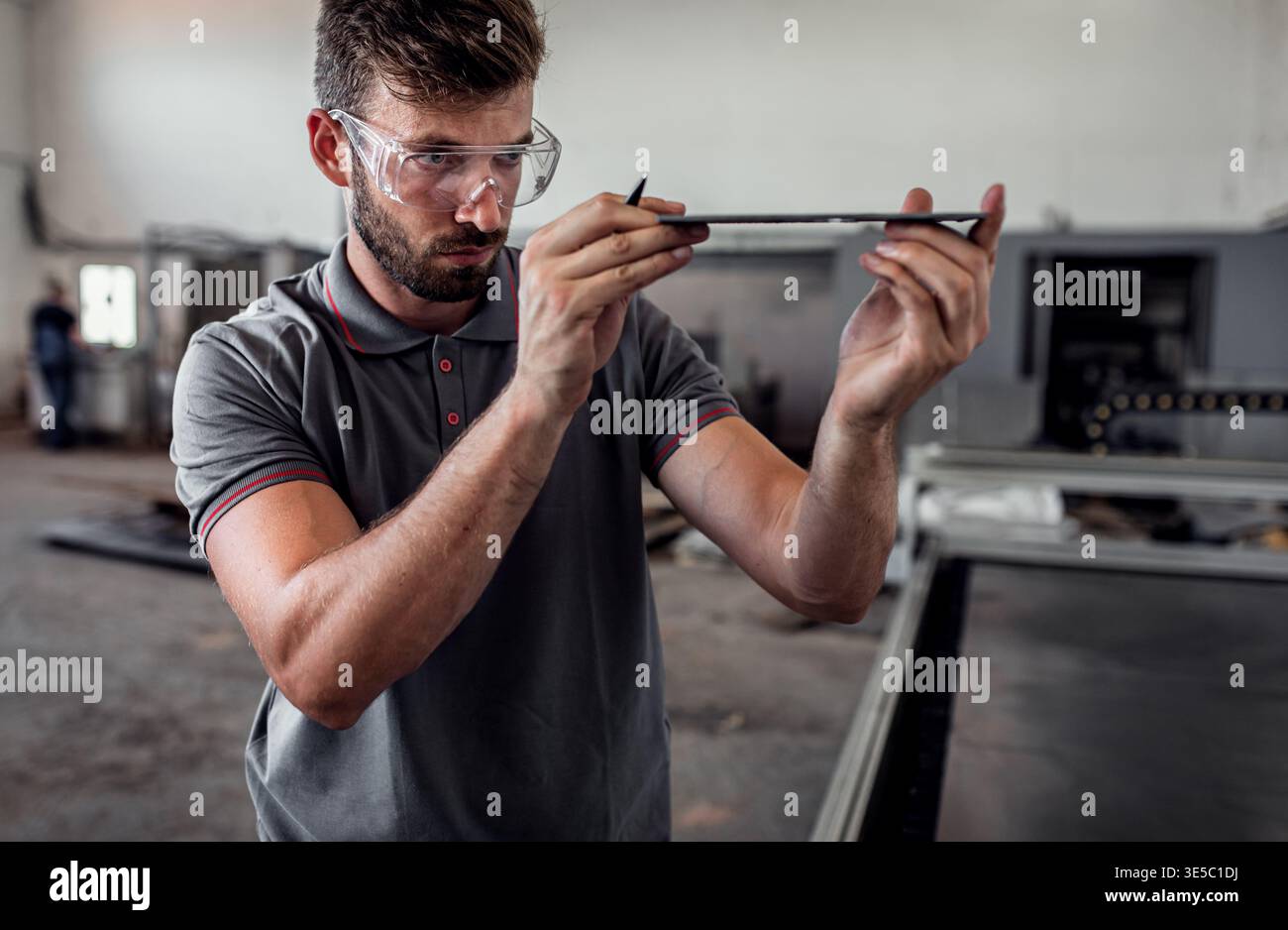Male engineer setup plasma cutter for work in metalwork workshop. Stock Photo