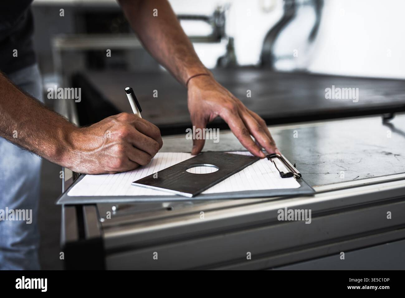 Male engineer setup plasma cutter for work in metalwork workshop. Stock Photo