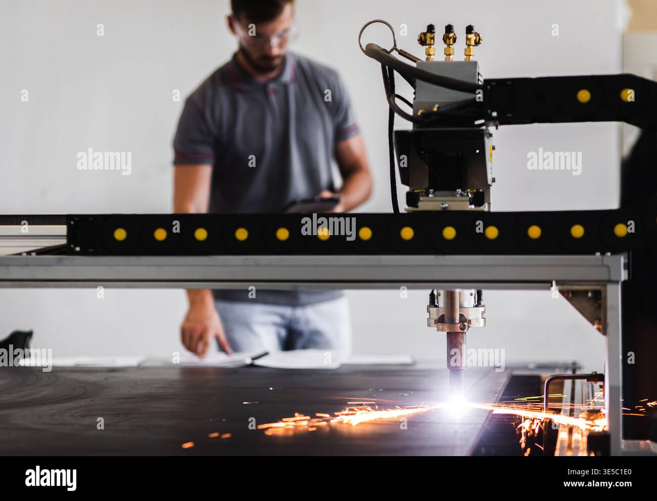 Male engineer setup plasma cutter for work in metalwork workshop. Stock Photo