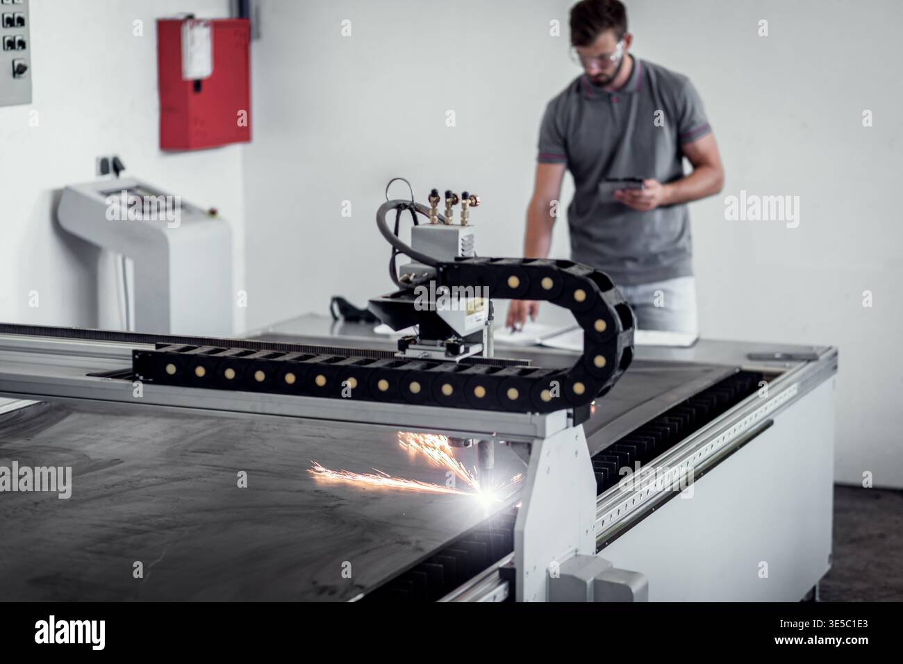 Male engineer setup plasma cutter for work in metalwork workshop. Stock Photo