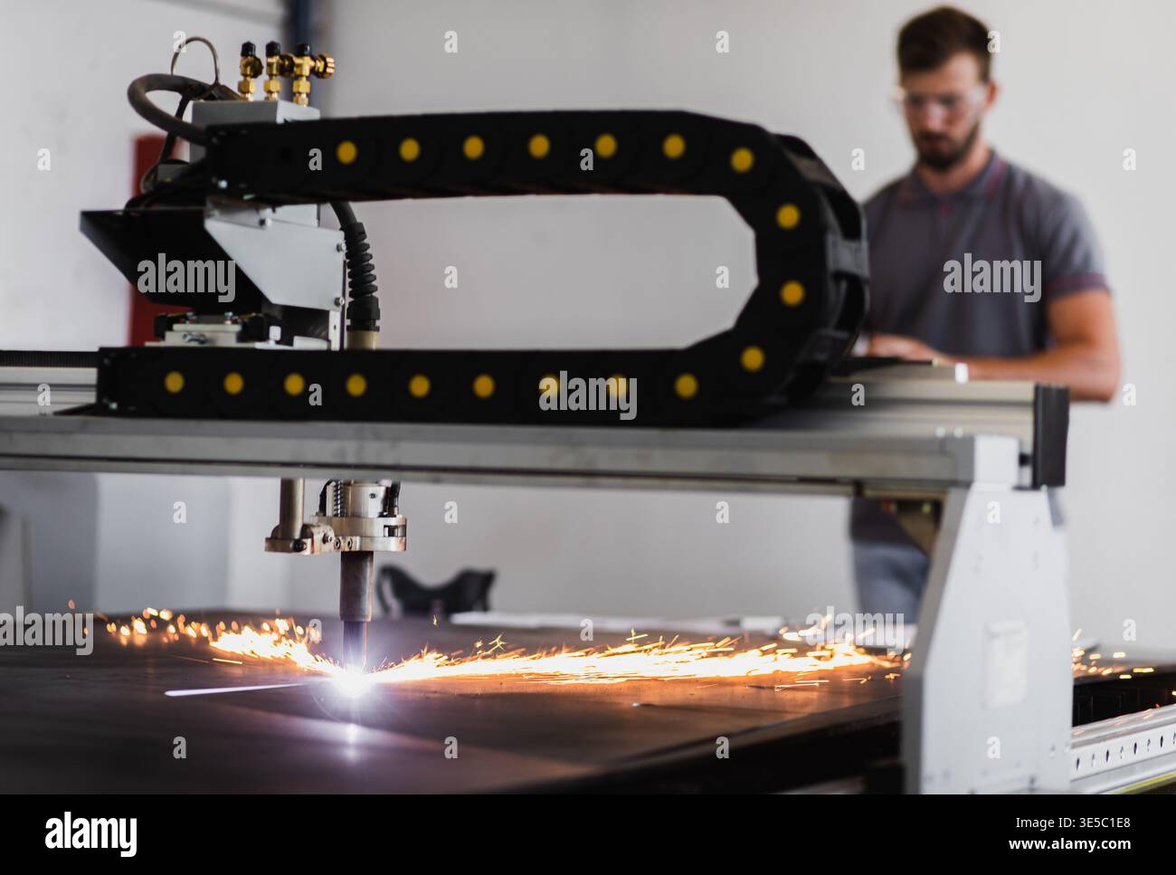 Male engineer setup plasma cutter for work in metalwork workshop. Stock Photo