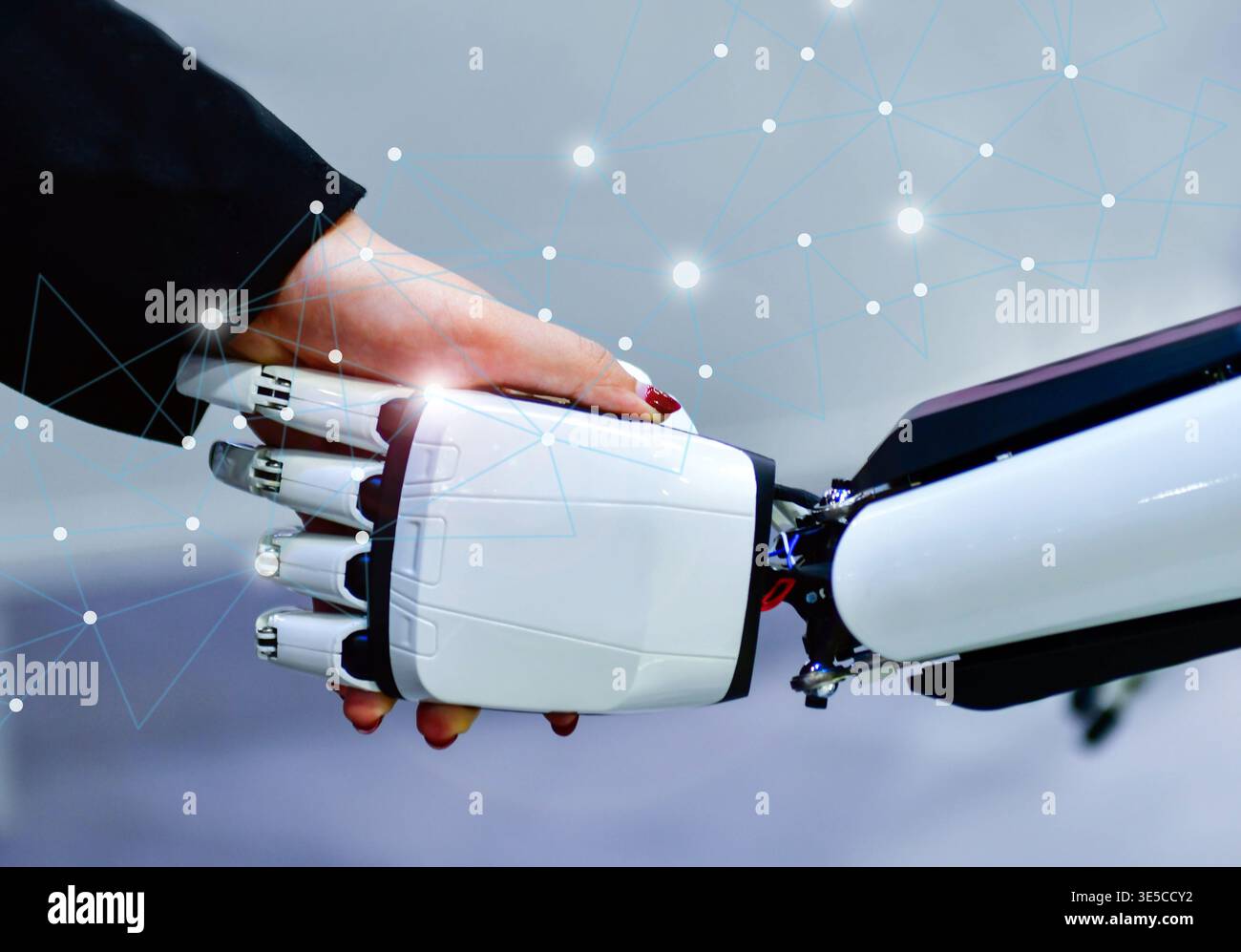 Advanced bionic robotic hand shaking hands with human, symbolizing AI and human collaboration. Stock Photo