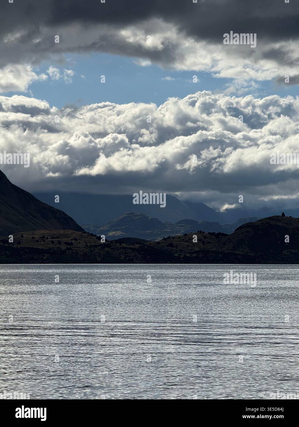 Dramatic cloudy sky over Lake Wanaka with bright sun breaking through, South Island, New Zealand - Smartphone Captured Stock Image