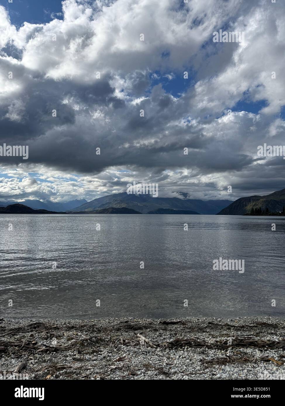 Dramatic cloudy sky over Lake Wanaka with bright sun breaking through, South Island, New Zealand - Smartphone Captured Stock Image