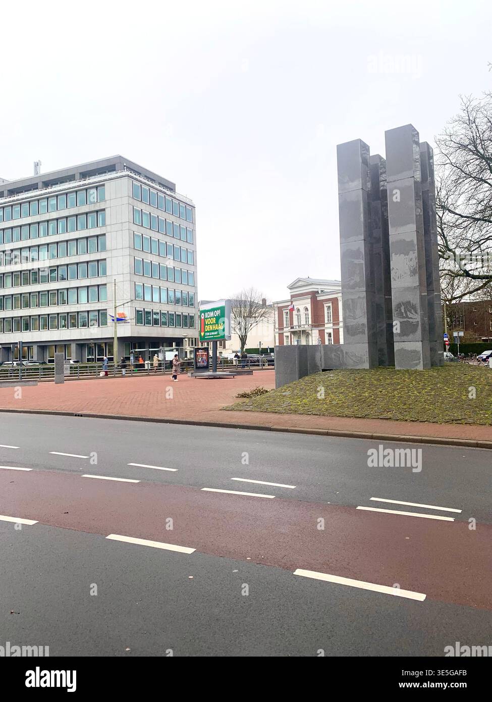 Modern office buildings and public transport at a busy plaza in the Hague Netherlands with pedestrians and cyclists moving through the urban space - Smartphone Captured Stock Image