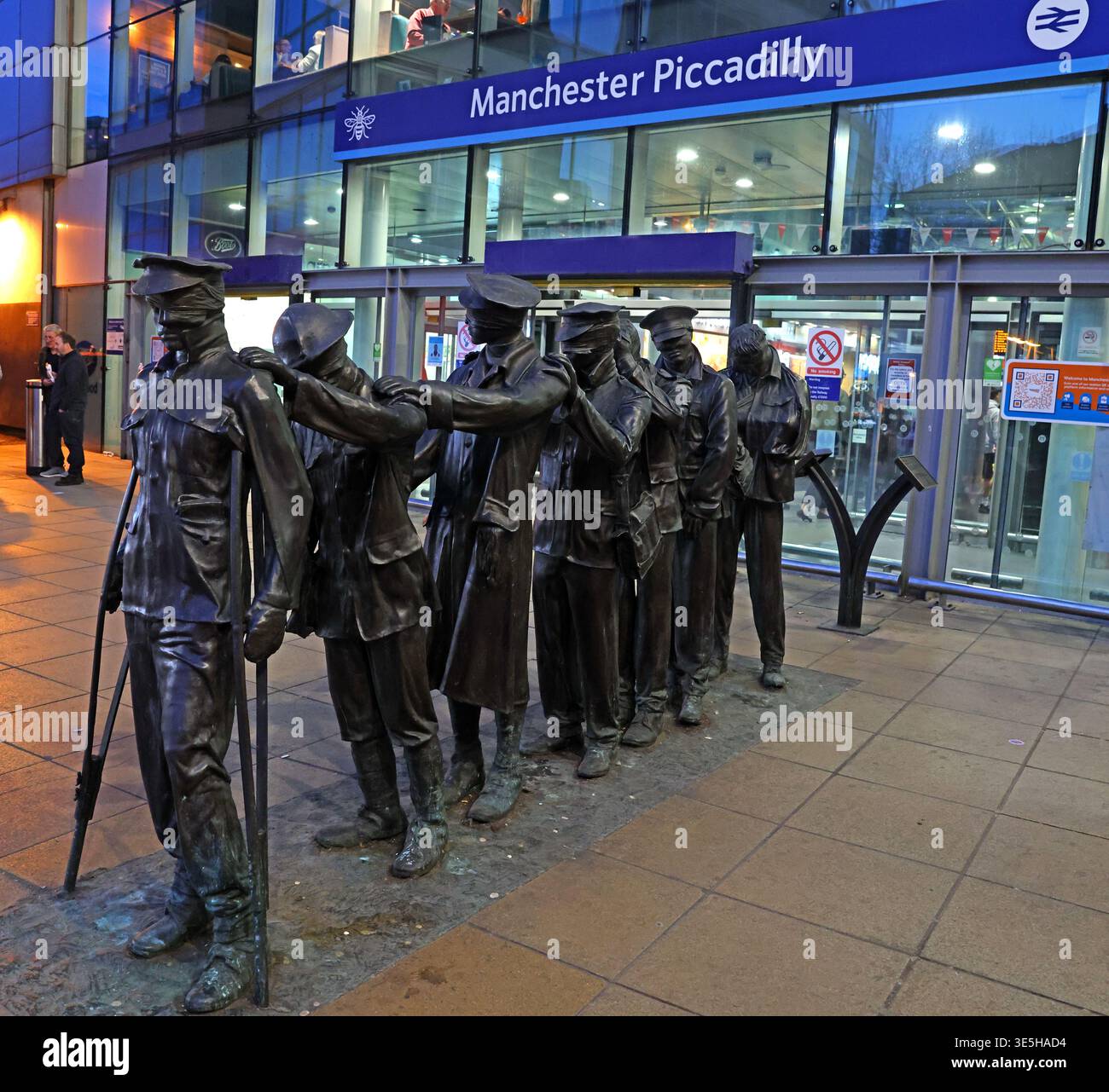 Victory Over Blindness bronze sculpture outside Manchester Piccadilly station at dusk, commemorating blinded First World War veterans Stock Photo