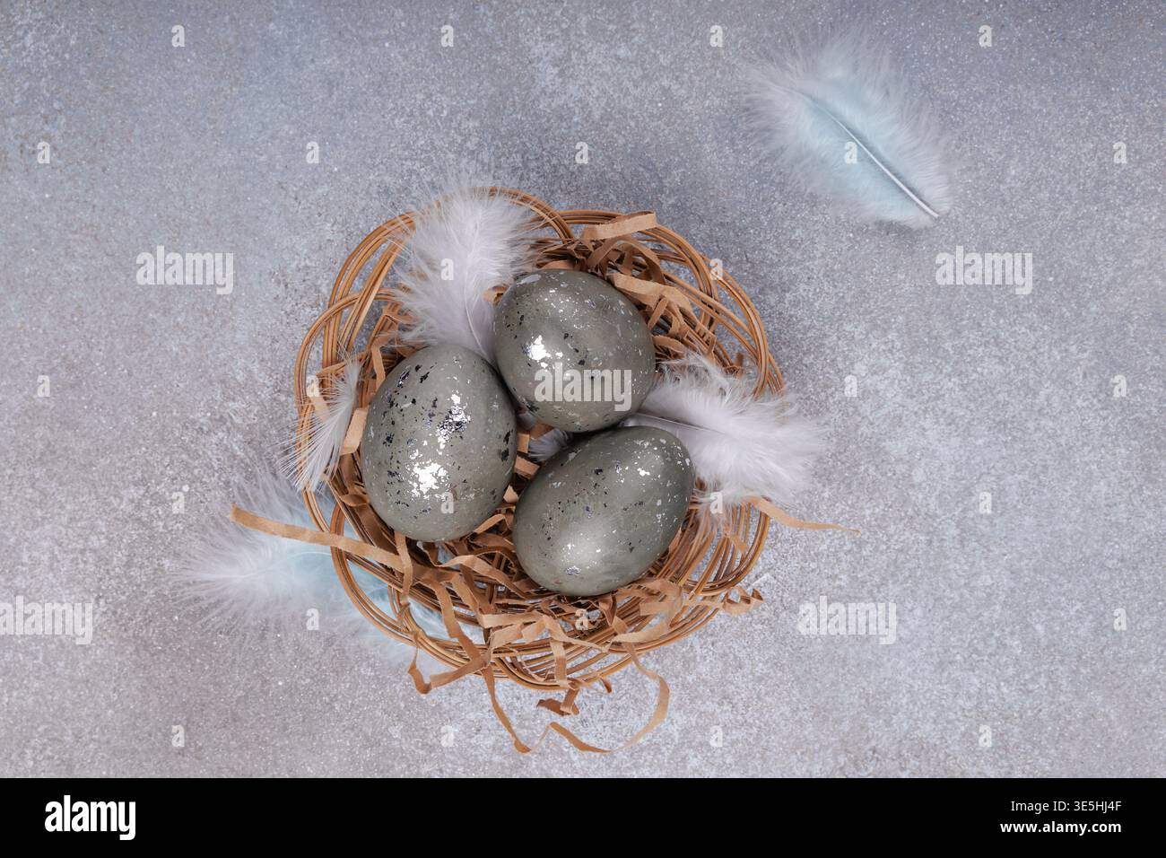 Top view Easter eggs with feathers in wicker nest Stock Photo