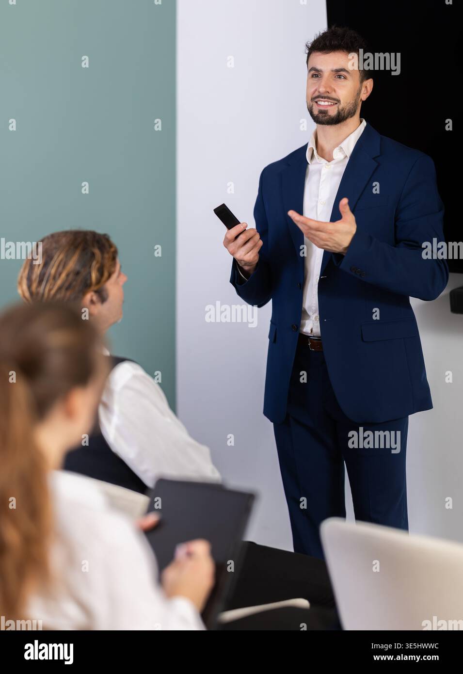 Male business trainer explaining topic to professionals using digital board Stock Photo