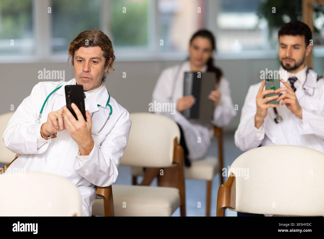 Medical students or doctors using mobile phones to scan QR-code during interactive lesson Stock Photo