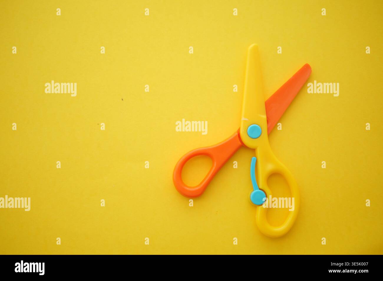 Scissors placed on a yellow background Stock Photo