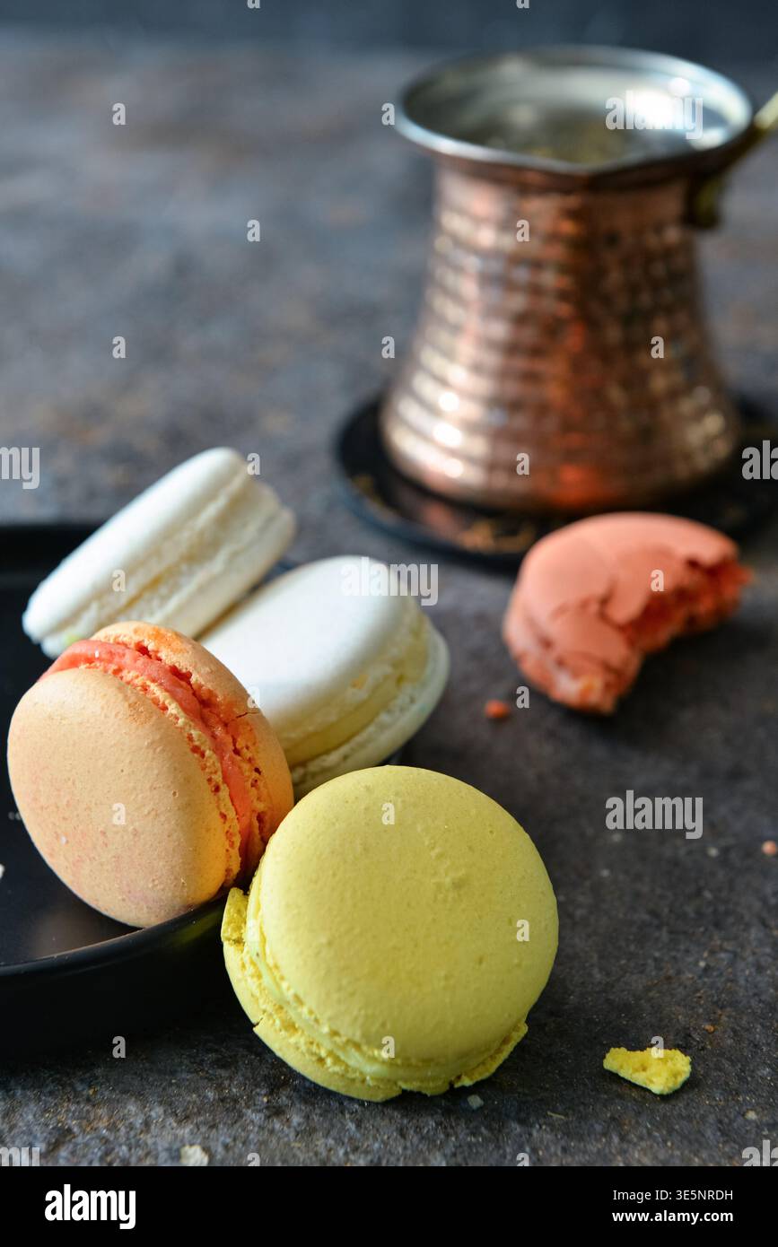 Plate with sweet macaroons on dark table Stock Photo