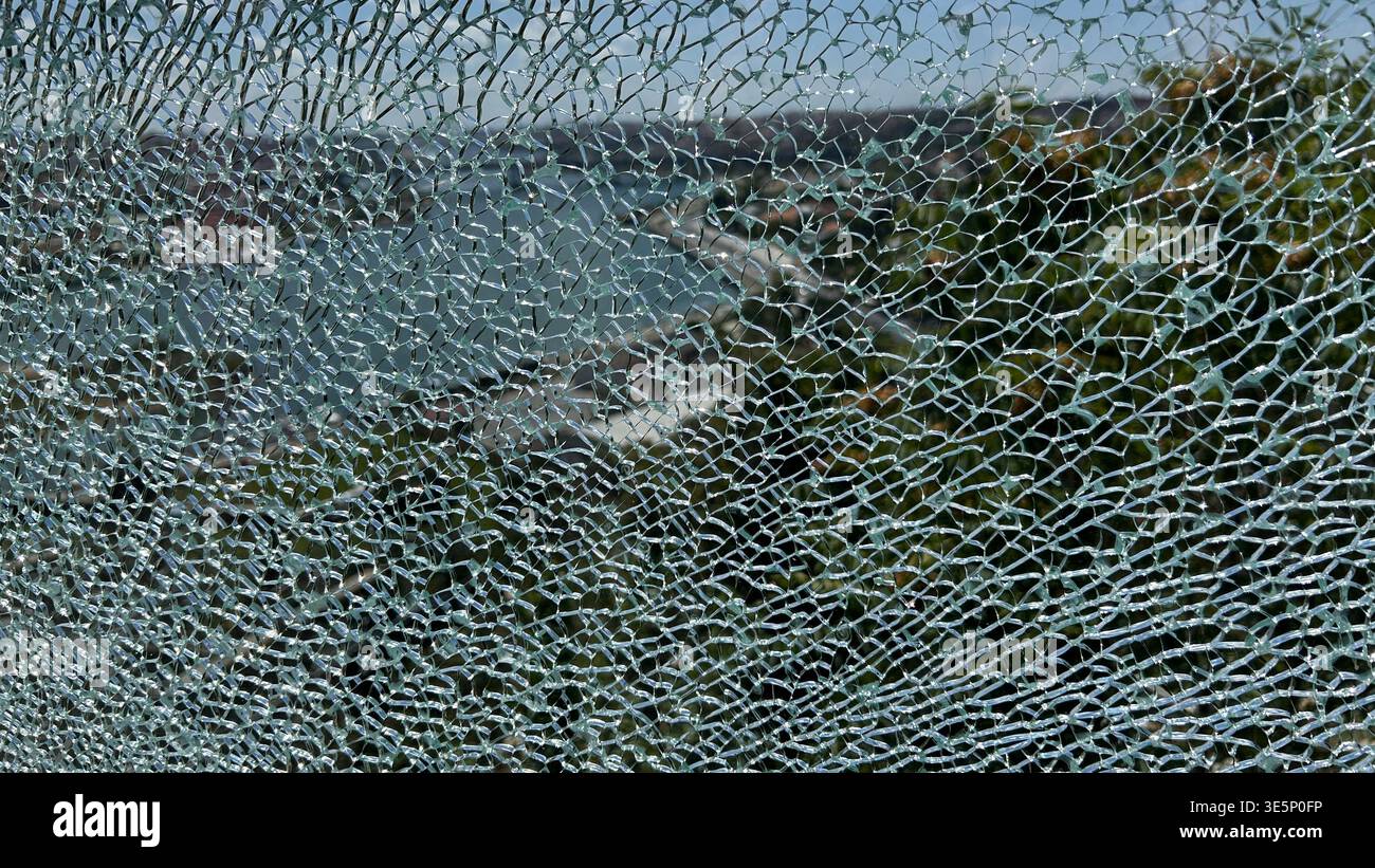 Shattered tempered glass window texture background, broken safety glass pattern background. Stock Photo