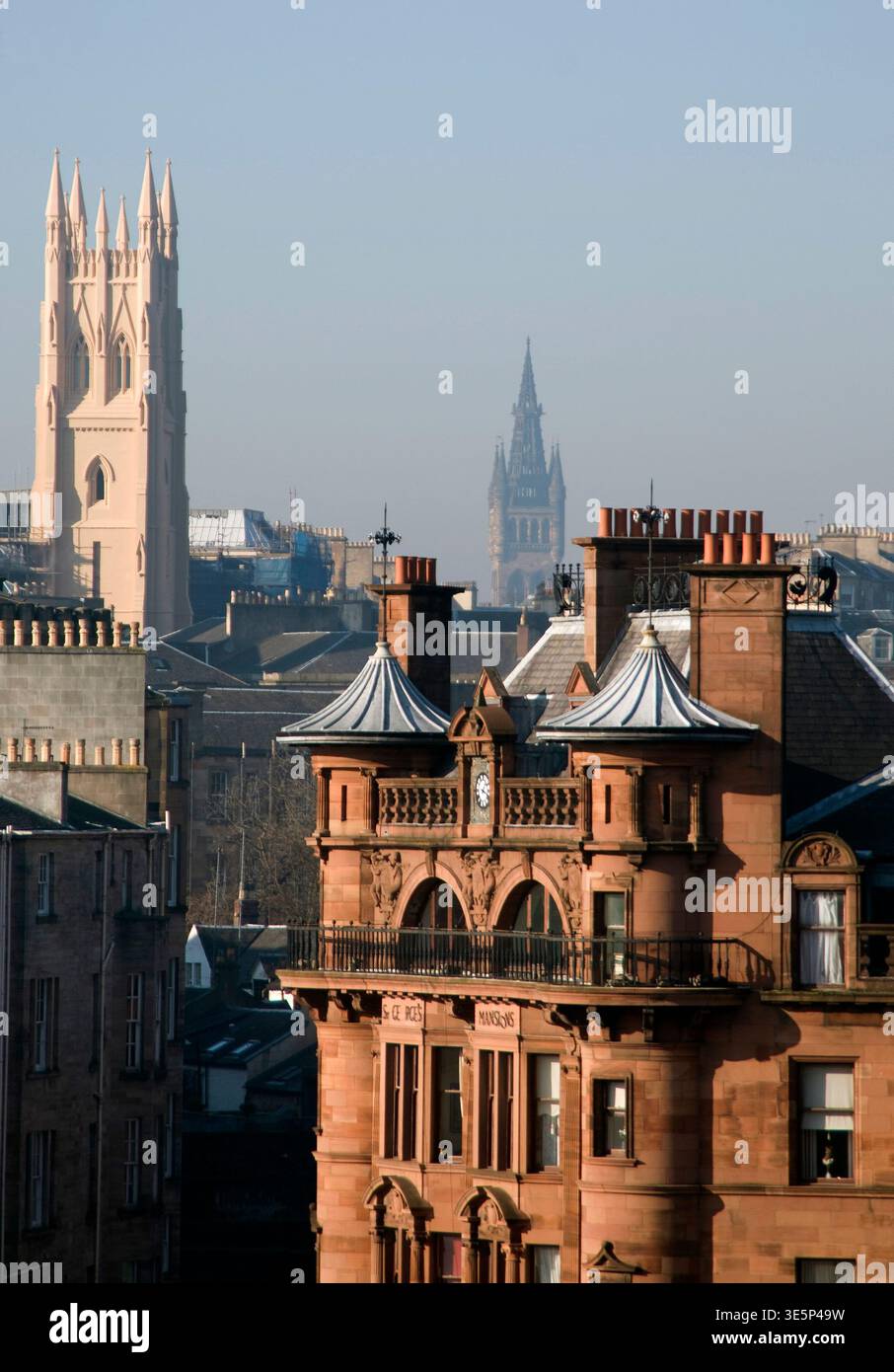Historic sandstone buildings and ornate rooftops at Charing Cross, Glasgow, framed by distant church spires and soft morning light, evoking urban heri Stock Photo