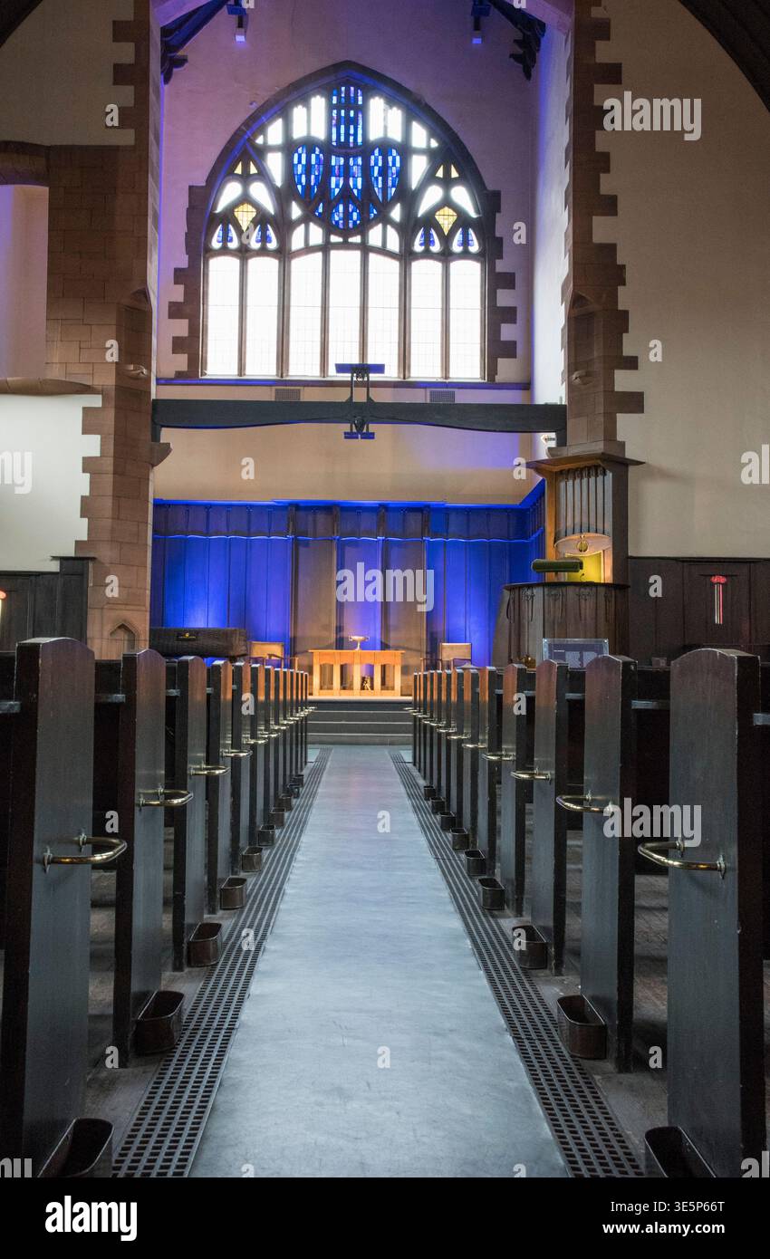 Dramatic church interior showing a central aisle lined with wooden pews ...