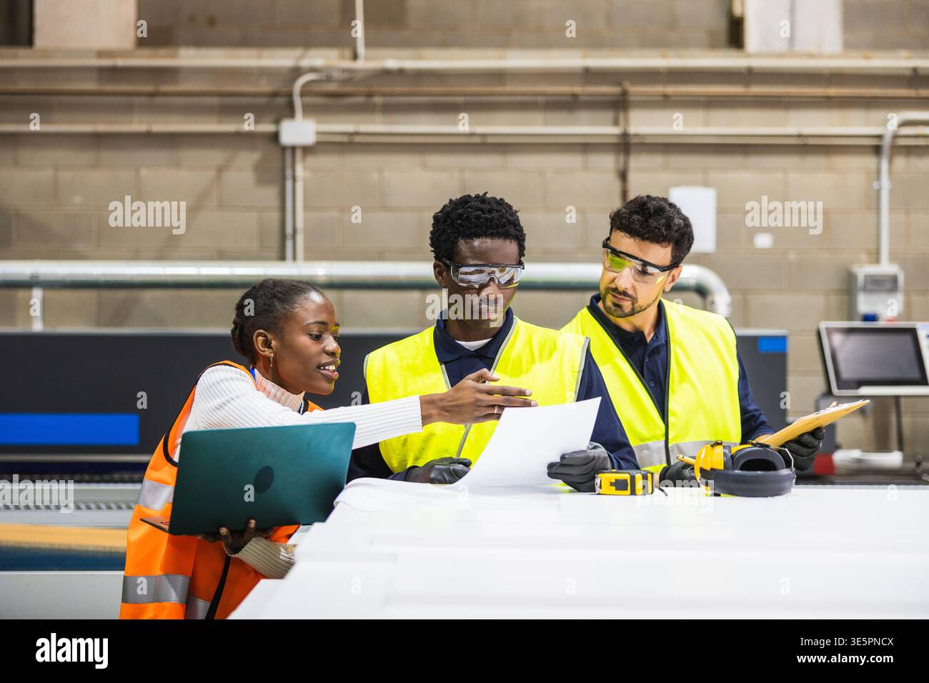 Diverse industrial workers collaborating on engineering plans Stock Photo