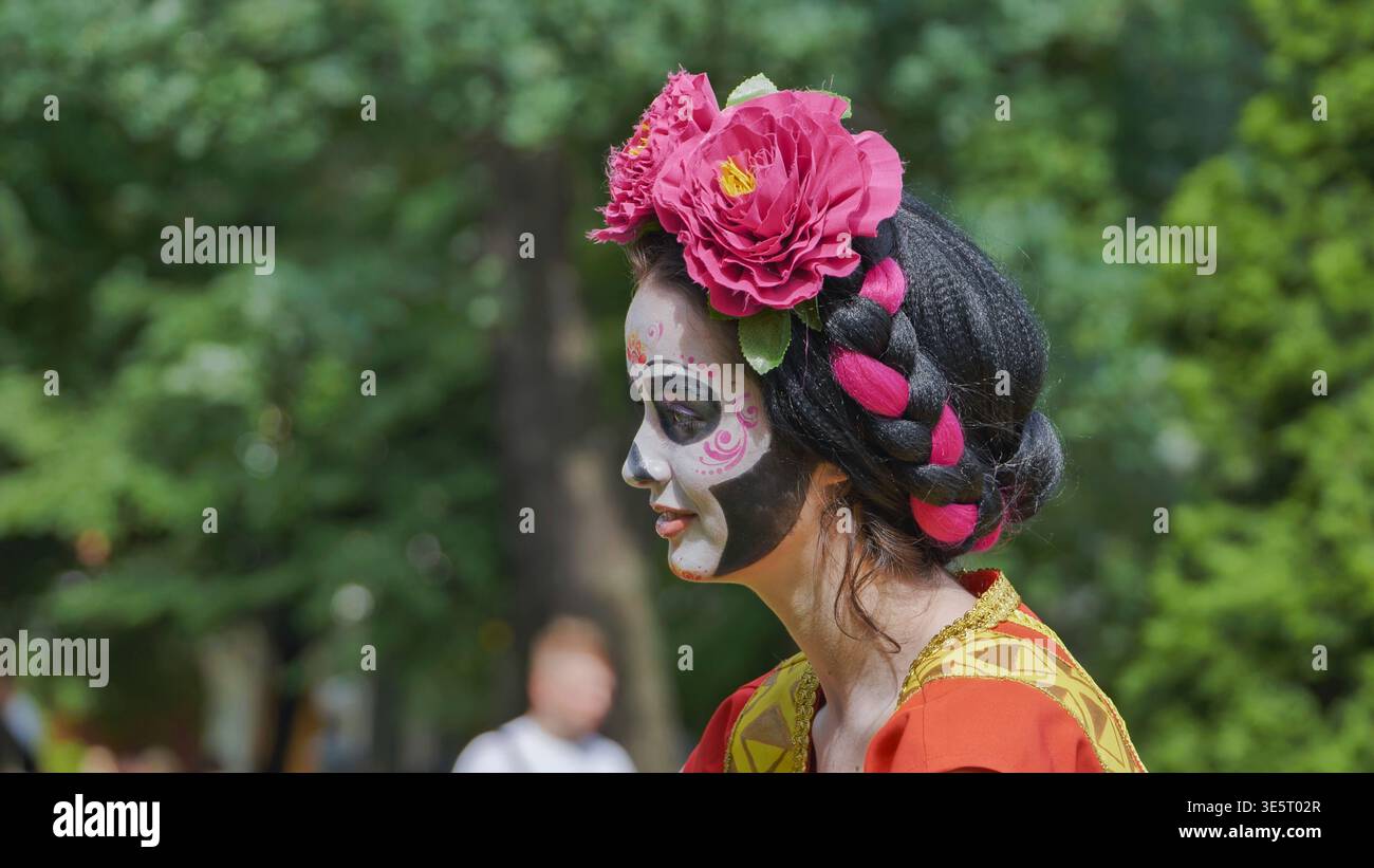 Woman wearing traditional costume with skull makeup and flower crown during a Mexican festival Stock Photo