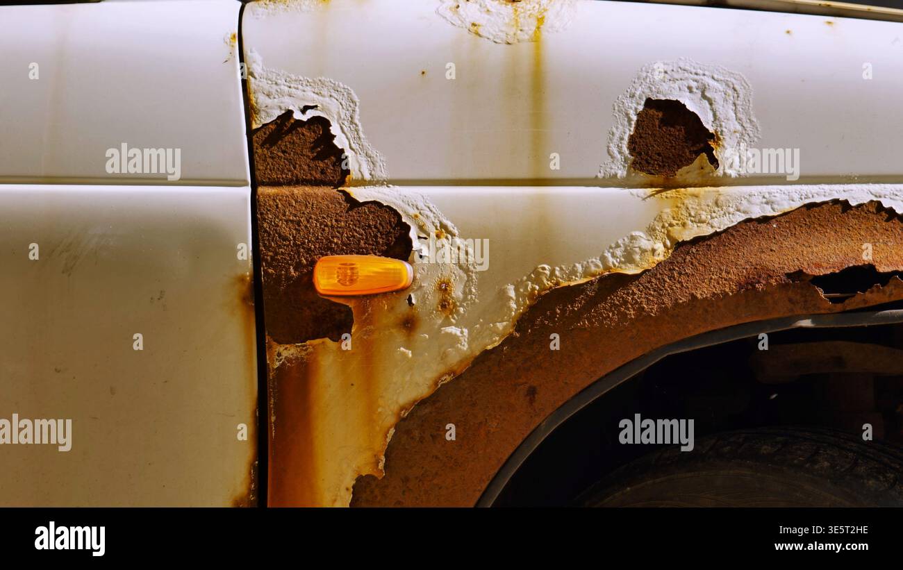 Car body corroding in Moscow, showing extensive rust damage and paint peeling Stock Photo
